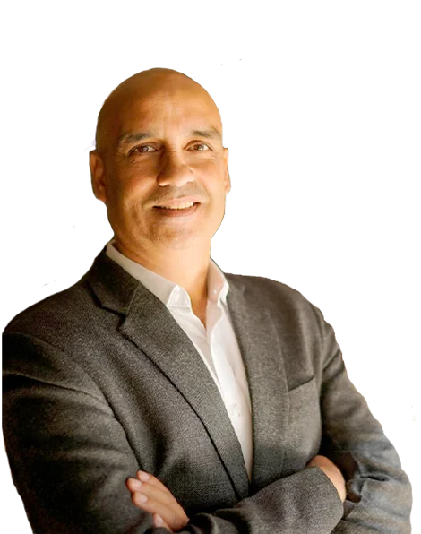 Greg Chapman in a grey blazer, smiling with his arms folded